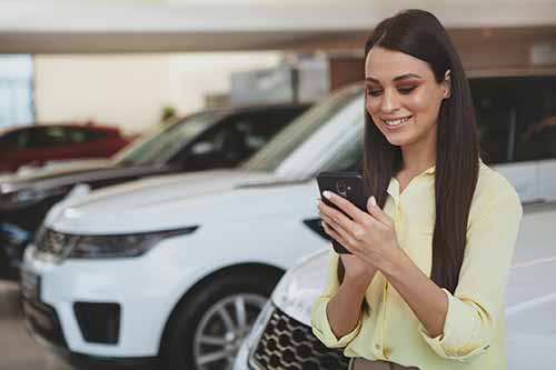 woman looking at cell phone for credit union auto loan