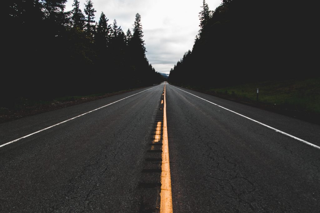 open road with dark trees