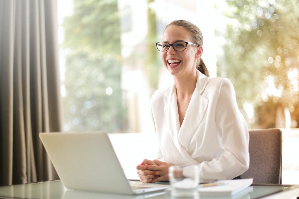 happy woman laughing with laptop