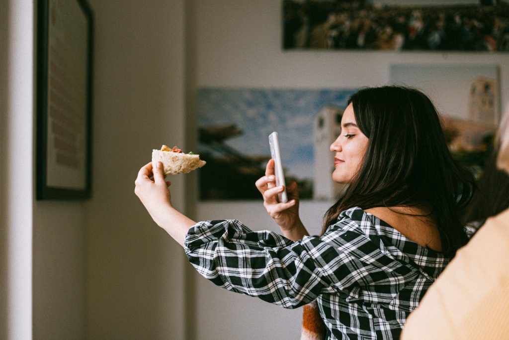 influencer taking photo of pizza with smartphone