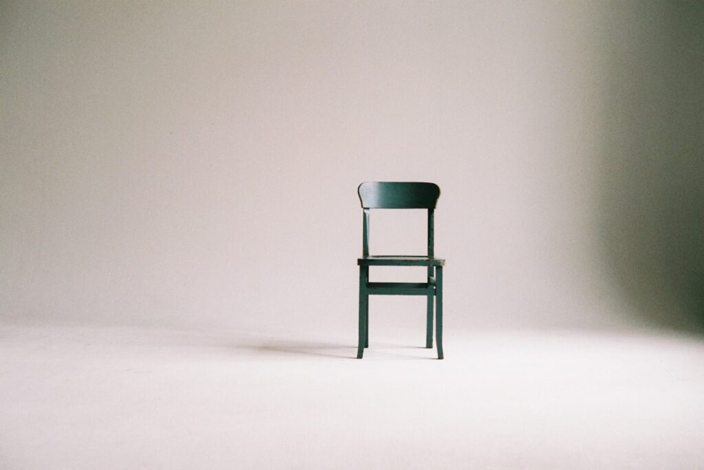 green wooden chair on white surface in empty room