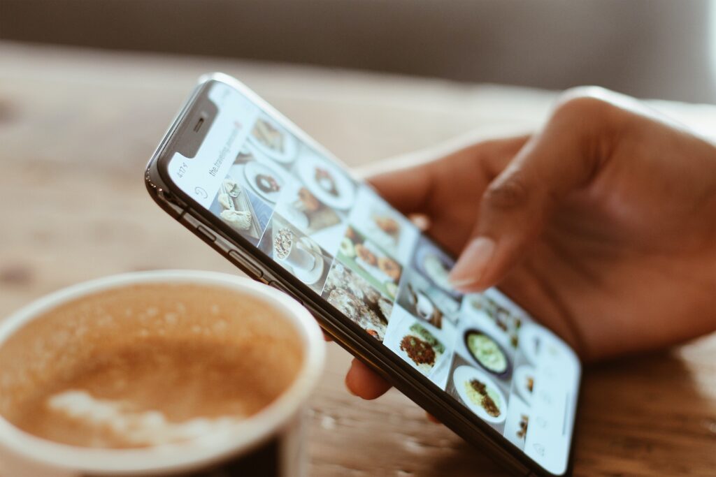 selective focus photography of person using iphone x scrolling through social media images