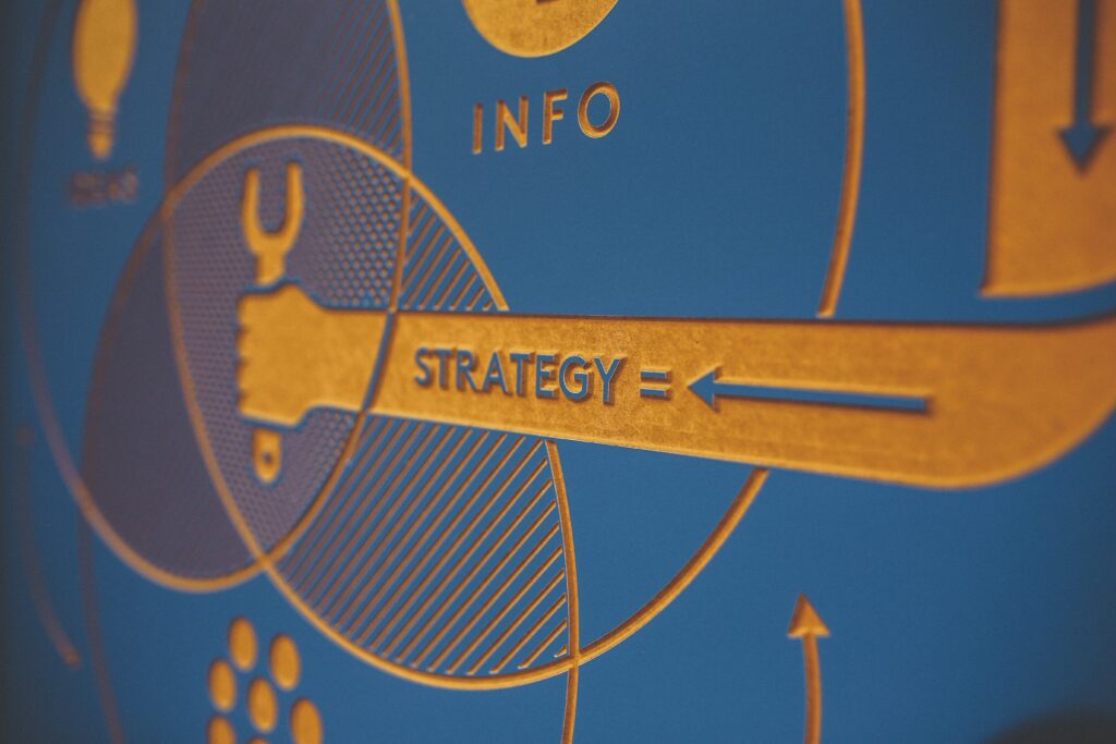 Closeup of blue board with yellow arrows with words info and strategy